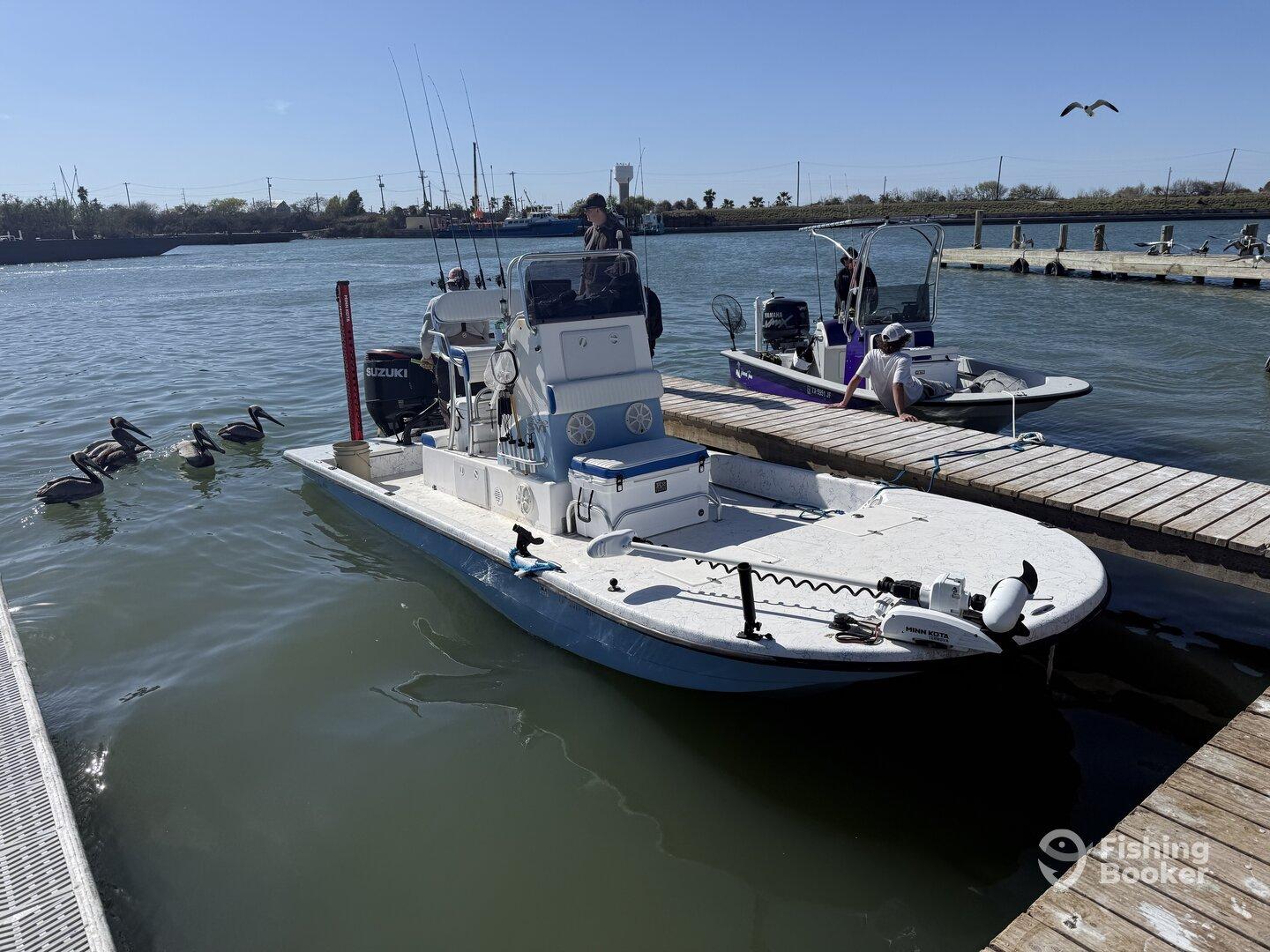 A scenic view of two fishing boats docked at a marina, with pelicans swimming nearby, showcasing a vibrant fishing environment.